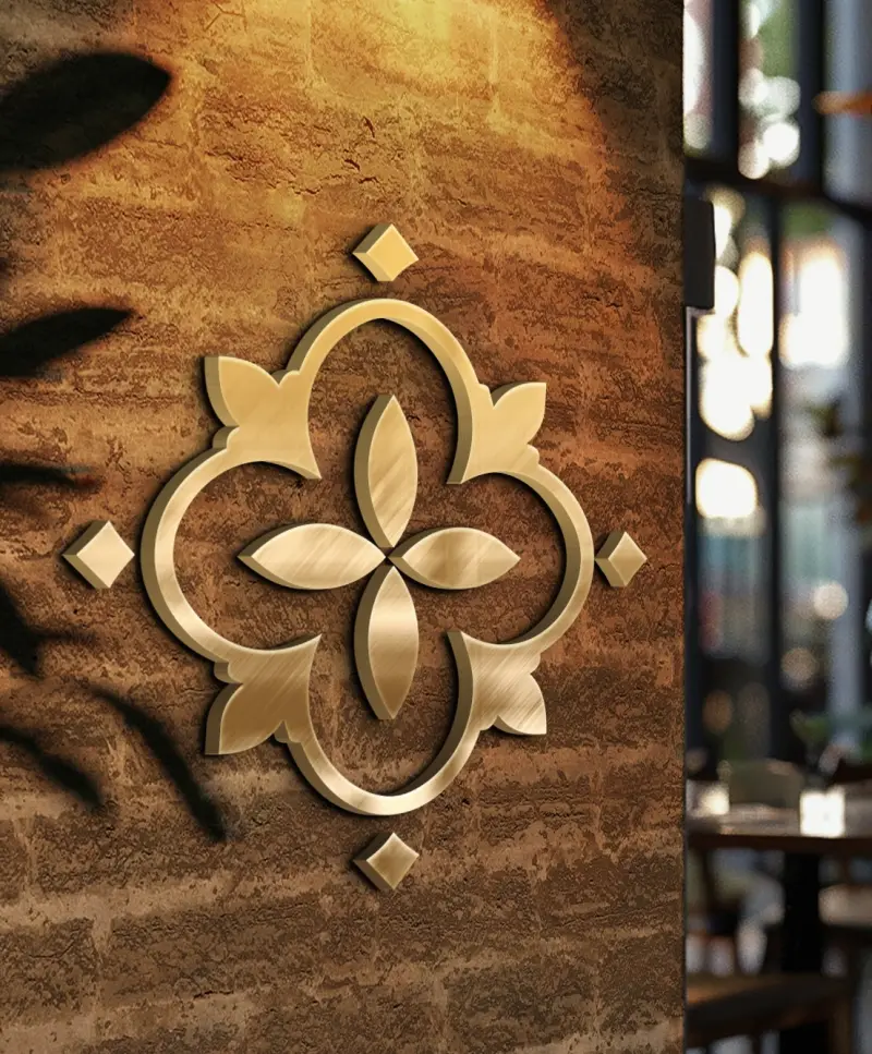 Emblema quadrifólio da Baldonni em latão dourado, aplicado na parede de tijolos do salão da pizzaria